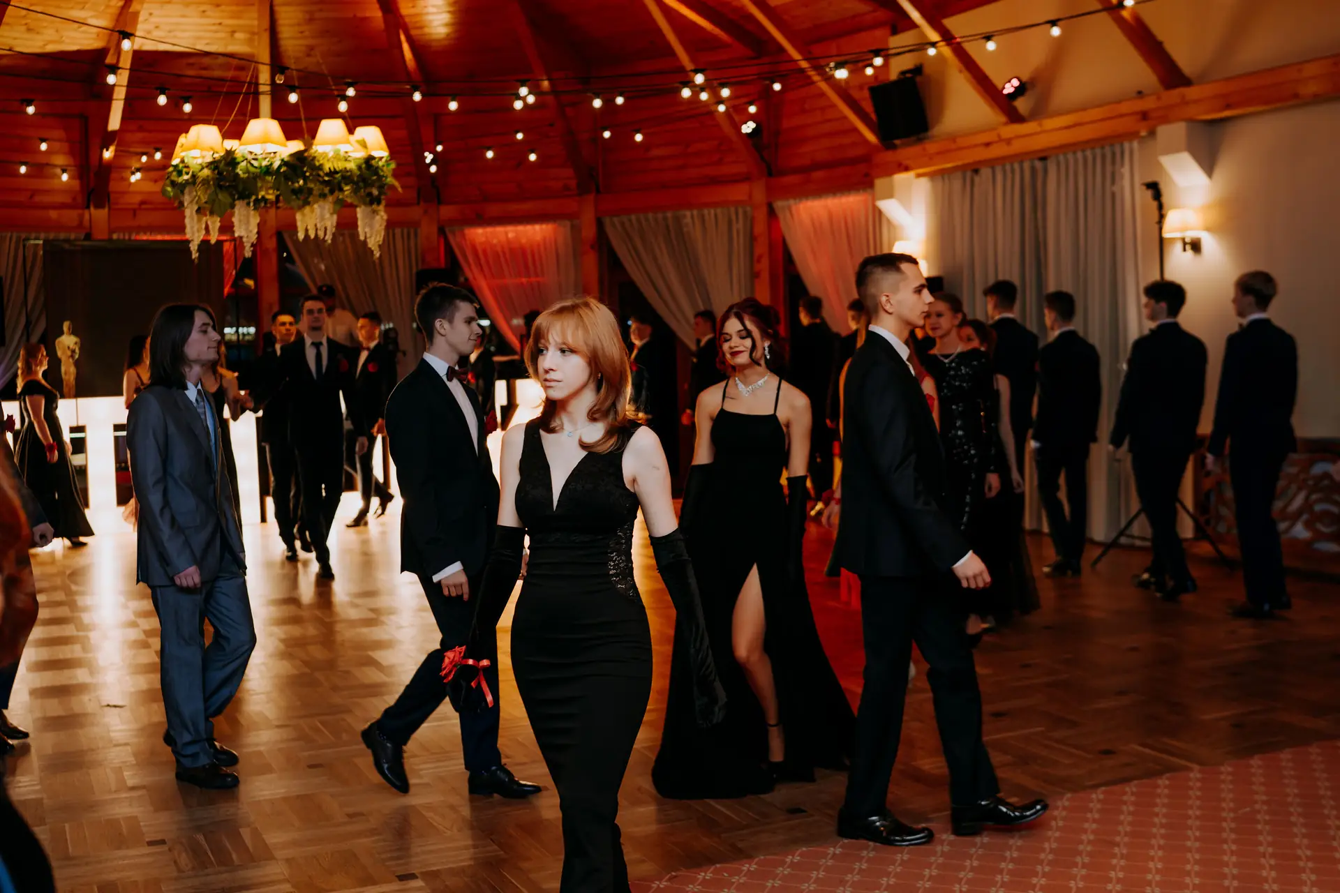 Pary w polonezie, za nimi świecące litery